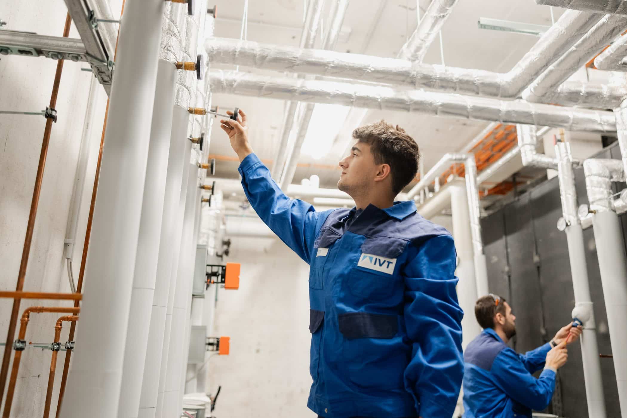 Auszubildender prueft Rohrleitungen in der Werkhalle der IVT Weiner + Reimann GmbH