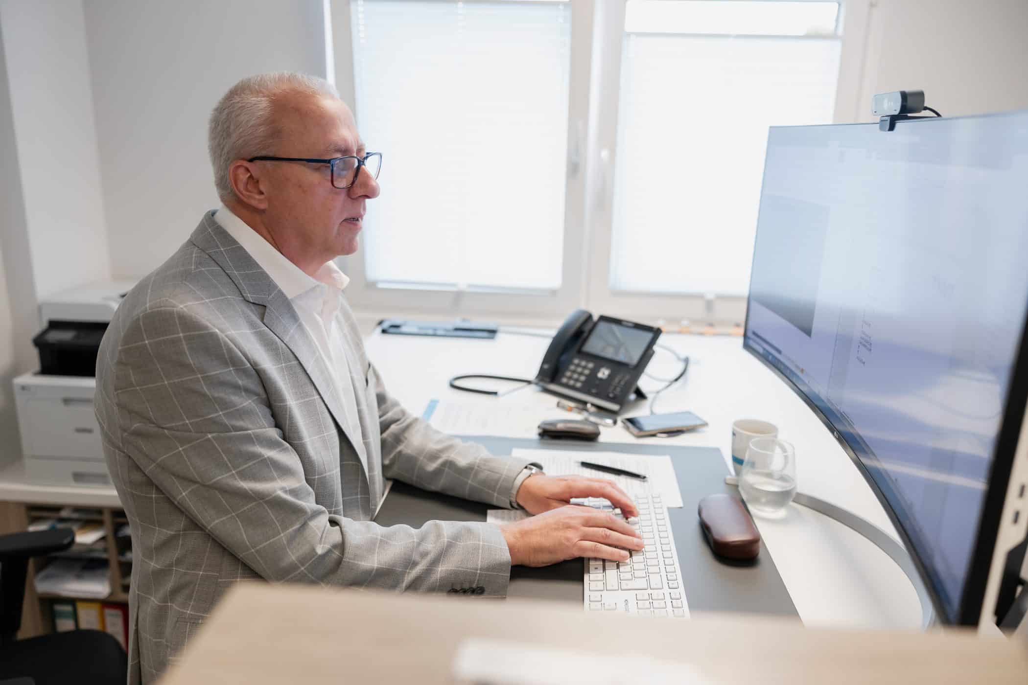 Mann mit Brille arbeitet am Computer bei IVT in Oberhausen