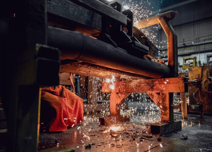 Funken spruehen bei Arbeit an grosser Maschine im Werk