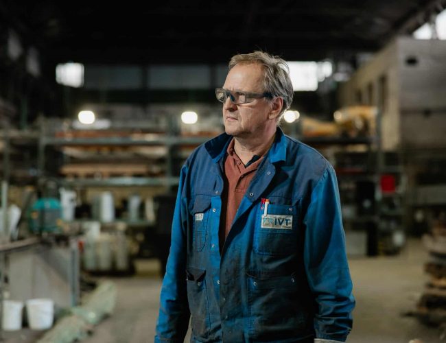 Mitarbeiter bedient Maschine in Werkhalle