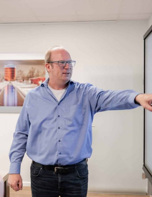 Mitarbeiter zeigt etwas bei Besprechung im Buero