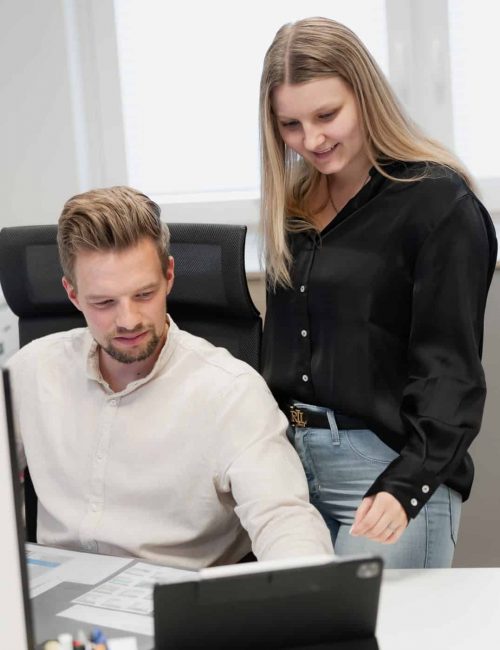 Mitarbeiter am Computer mit zwei Kolleginnen neben ihm