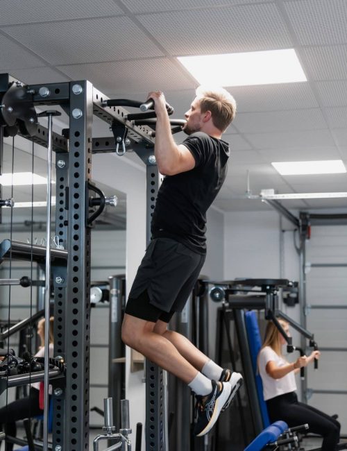 Mitarbeiter trainiert an Kraftgeraet im Fitnessraum