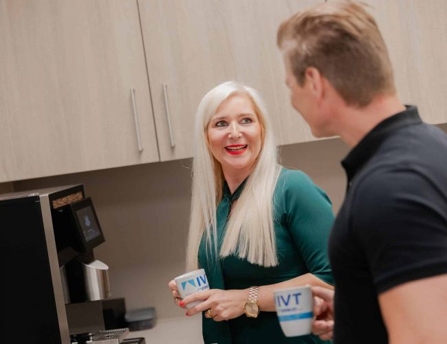 Mitarbeiterin begruesst Besucher am Empfang